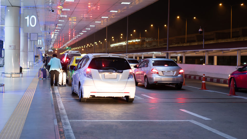 Navette de parking aéroport prenant en charge des voyageurs avec bagages